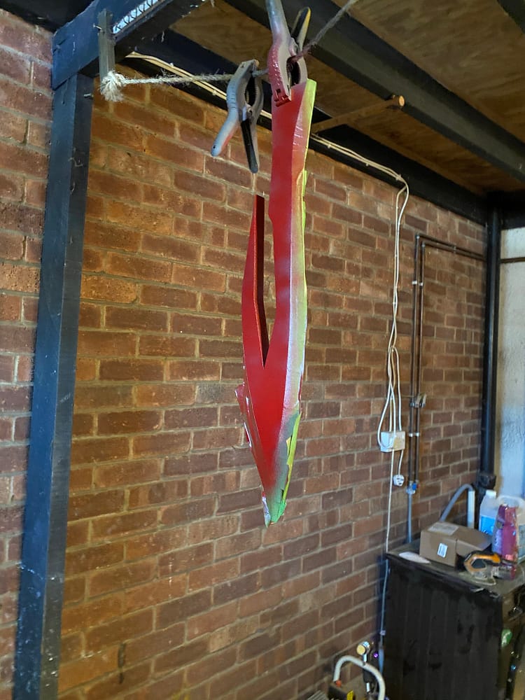 The sword being sprayed red while hanging from a rope
