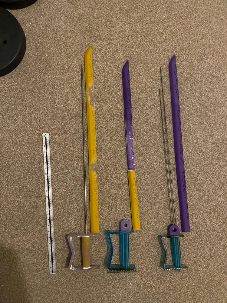 Image of three full sets of sword components. Left, prototype one. Right, prototype two. Middle spare parts from failures.