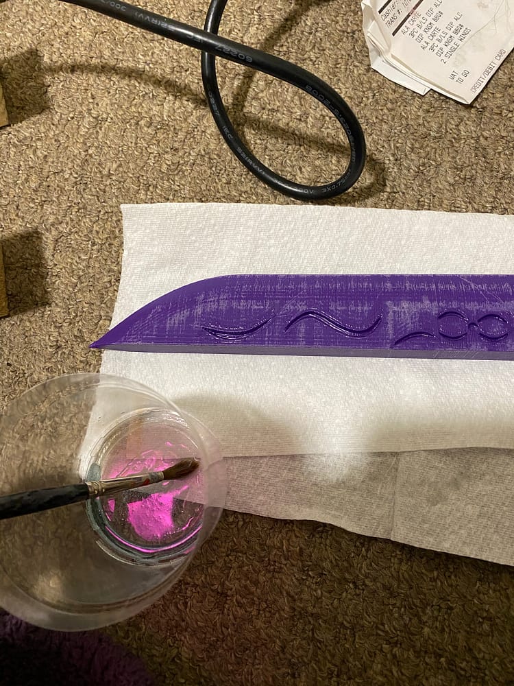 Image of the blade component with some UV resin in a small pot and a paintbrush.