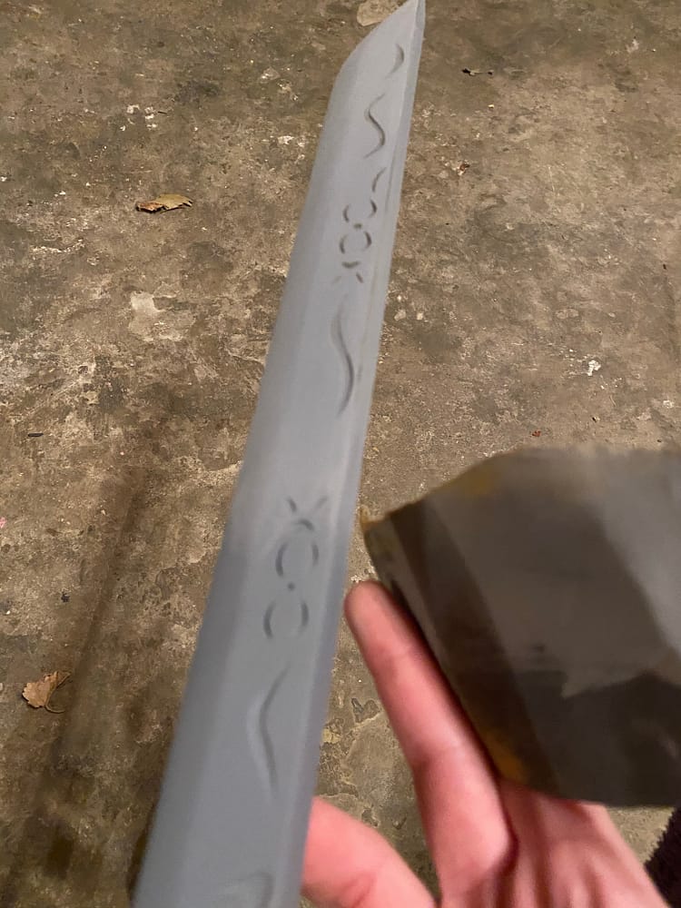 Grey primed blade being sanded.