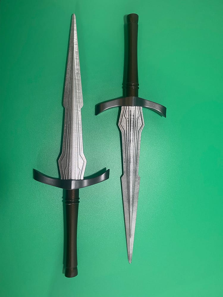 Two finished daggers in parallel on a green background.